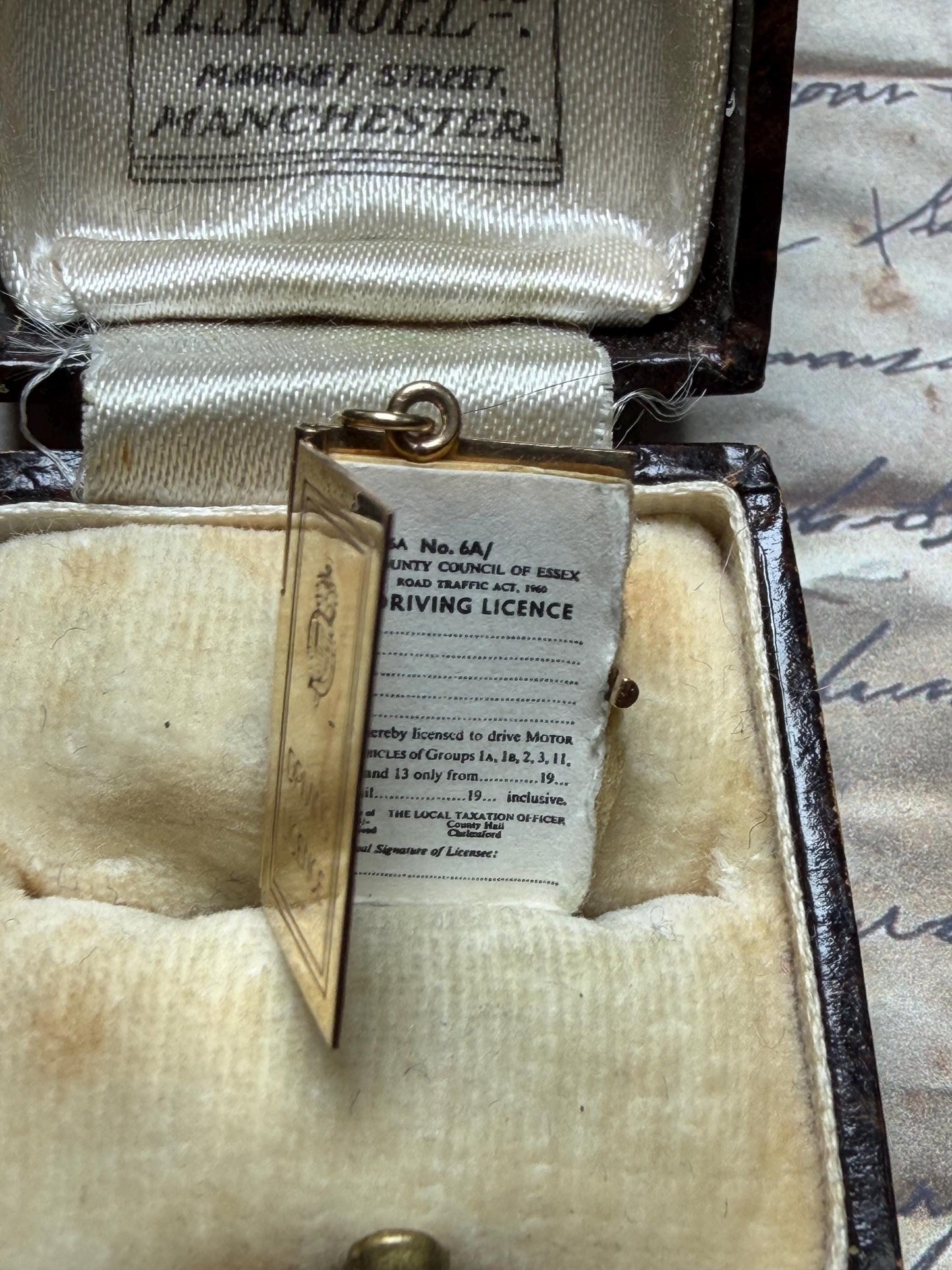 9 ct driving licence charm in really good condition for age - fully opens with papers inside .