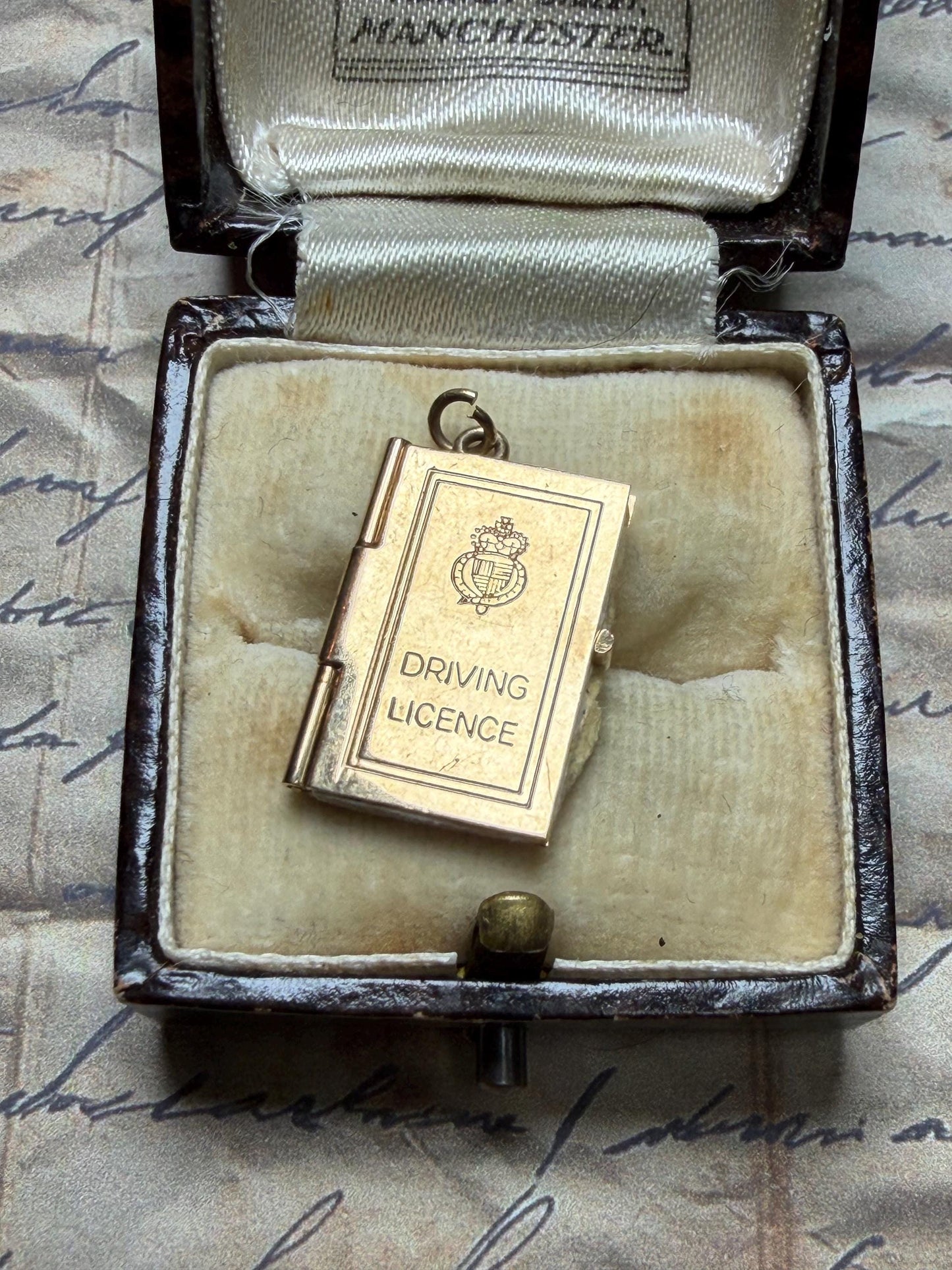 9 ct driving licence charm in really good condition for age - fully opens with papers inside .