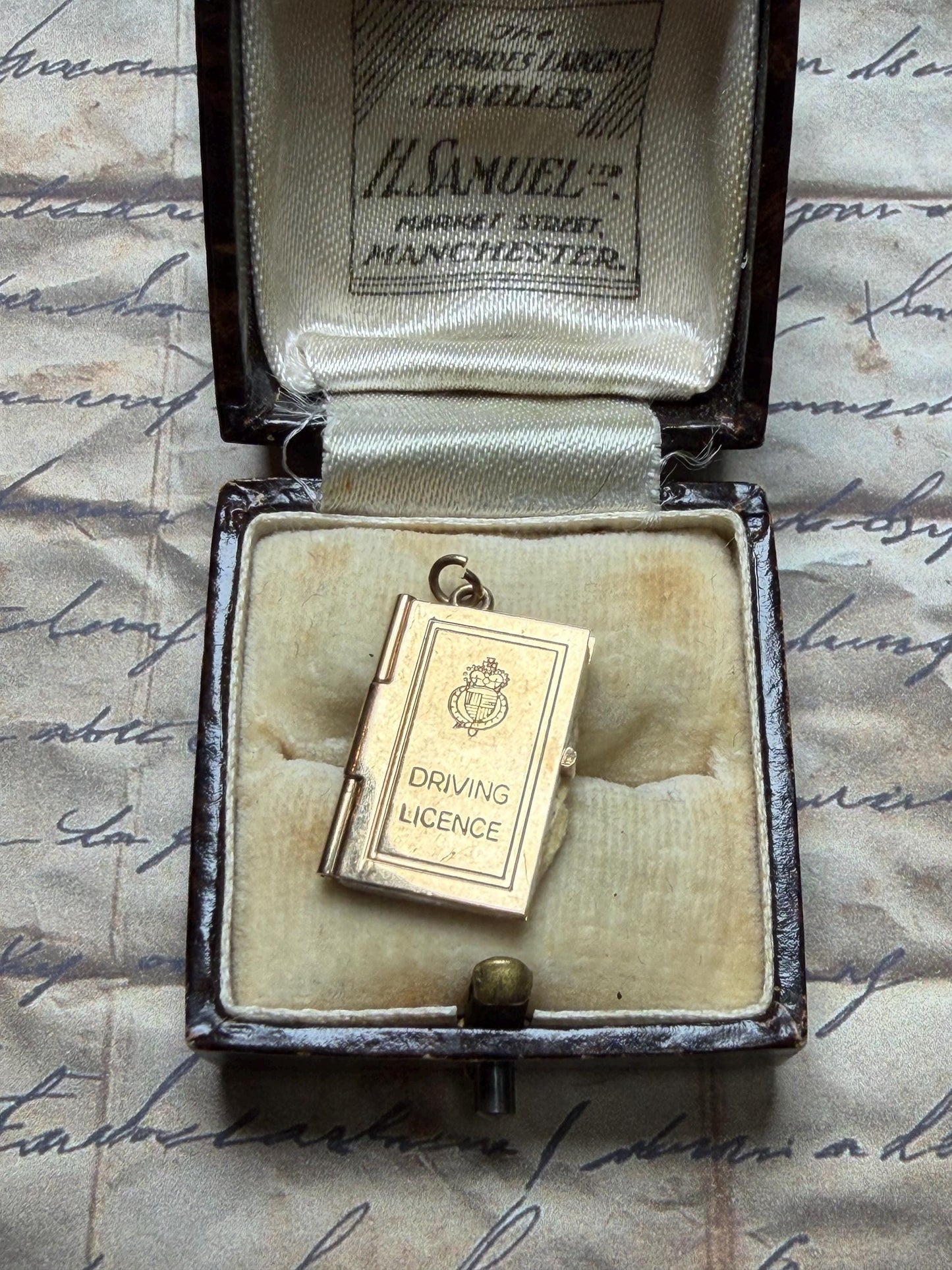 9 ct driving licence charm in really good condition for age - fully opens with papers inside .