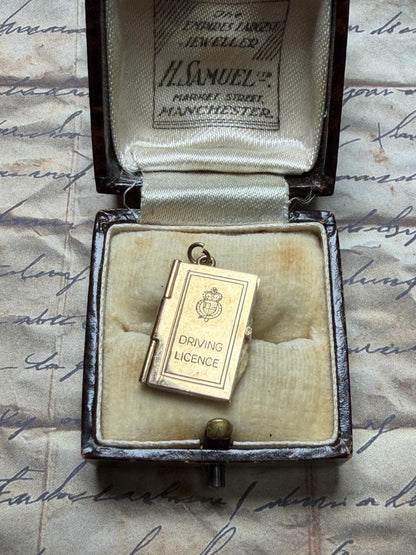 9 ct driving licence charm in really good condition for age - fully opens with papers inside .