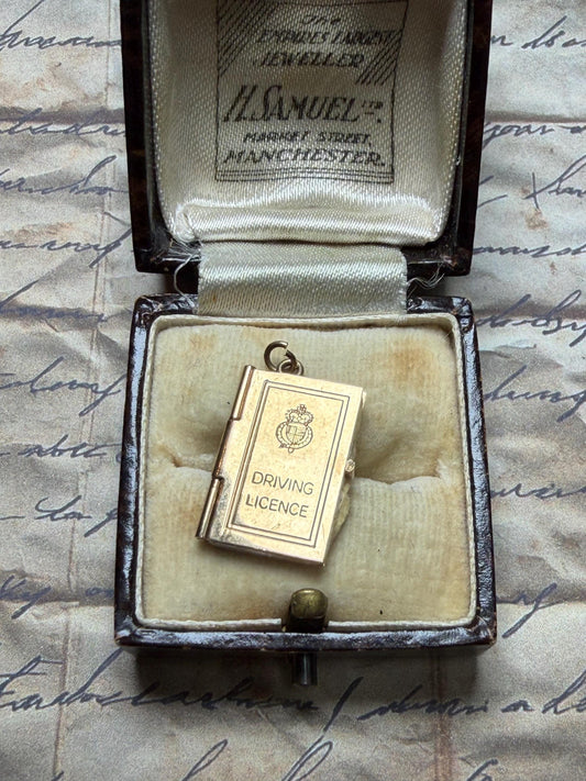 9 ct driving licence charm in really good condition for age - fully opens with papers inside .